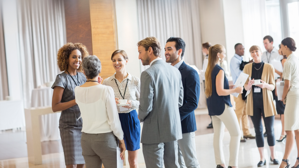 un groupe de professionnels en train de discuter et de réseauter lors d'un événement d'entreprise.