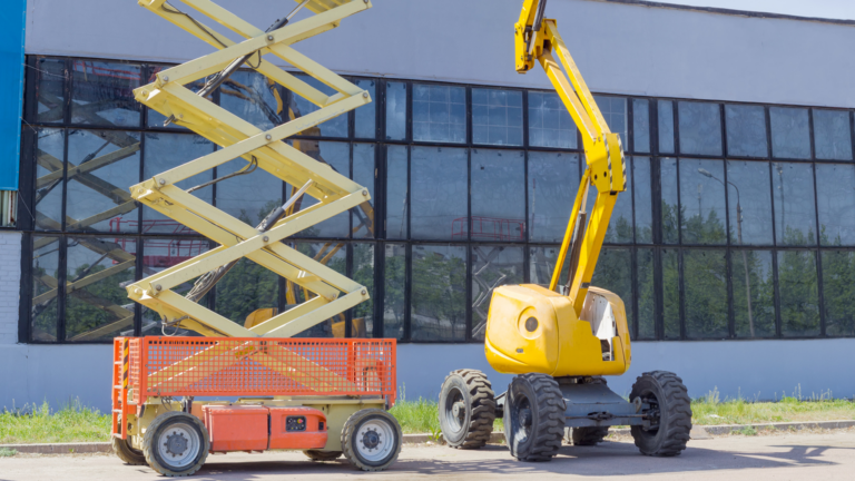Une photo montrant deux types de nacelles élévatrices de couleur jaune garées devant un bâtiment industriel aux larges vitres : à gauche, une nacelle à ciseaux avec sa plateforme orange au repos, et à droite, une nacelle à bras articulé équipée de pneus tout-terrain.