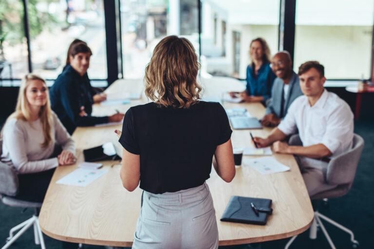 réunion de travail avec plusieurs professionnels autour d'une grande table de conférence.