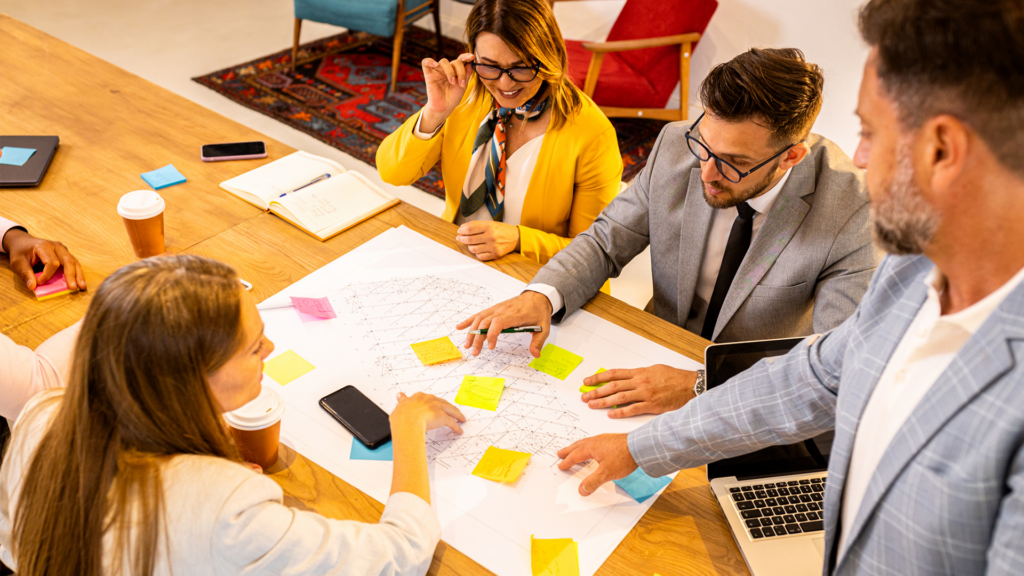 une équipe de professionnels lors d'une séance de travail collaborative autour d'une table en bois